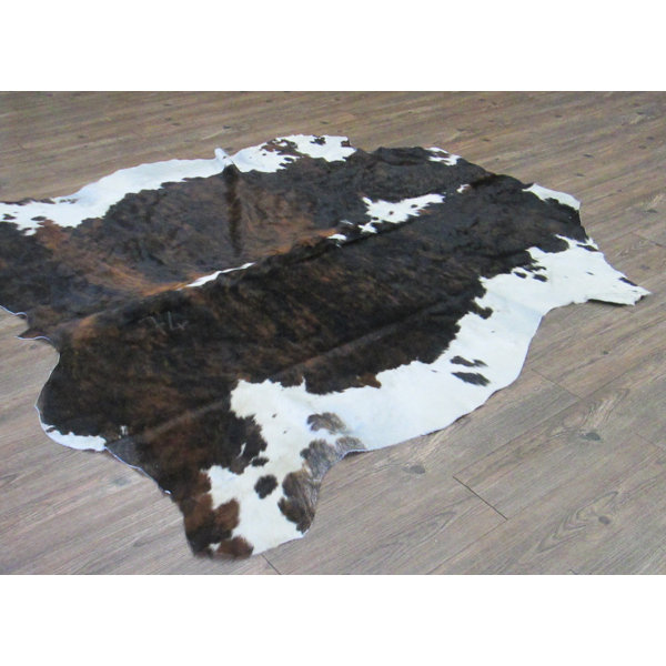 Tomlinson Hand-Woven Cowhide Black/Brown Area Rug by Loon Peak