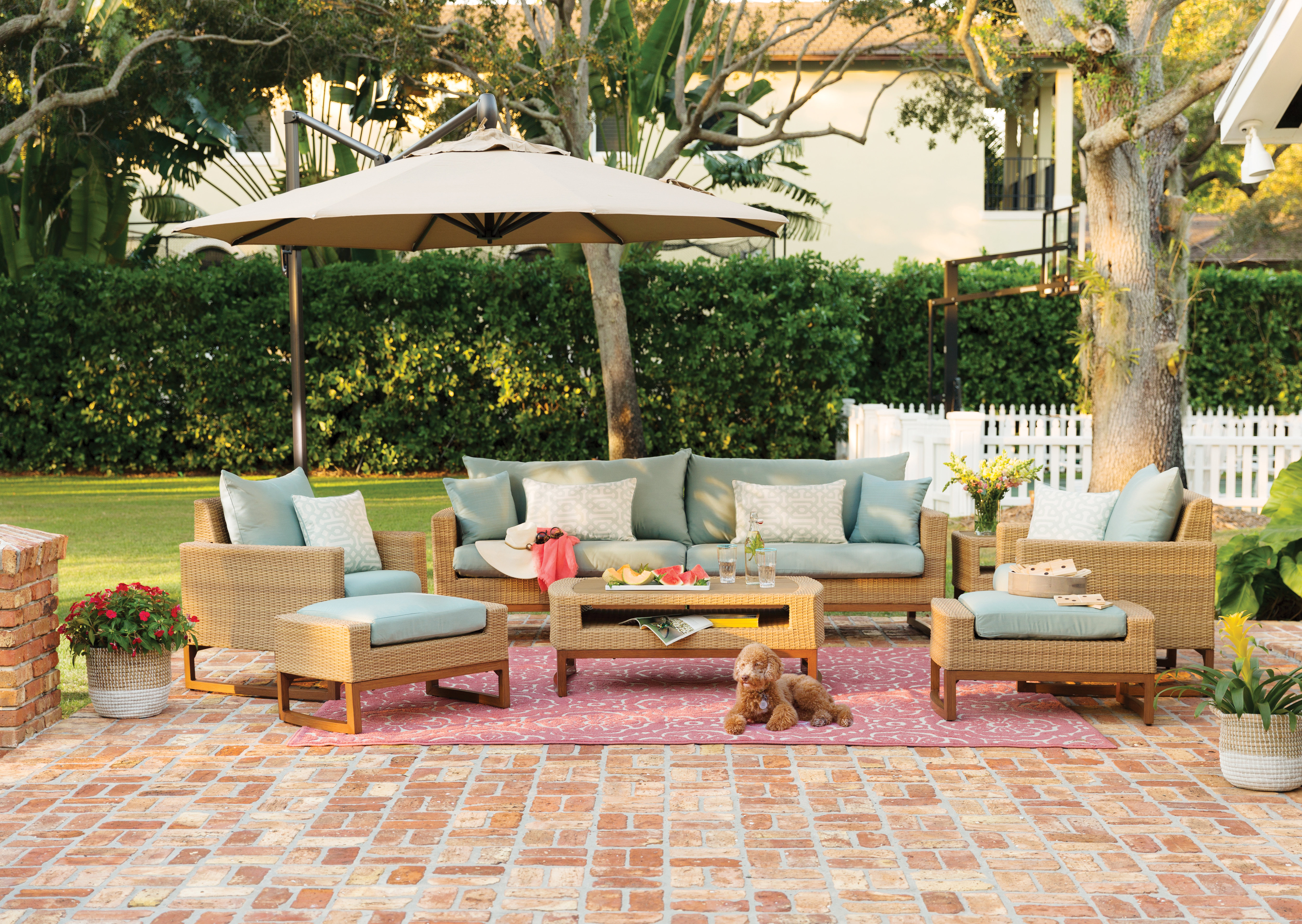 outdoor conversation set on a patio shaded by a cantilever umbrella