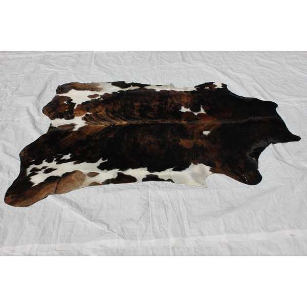 Tourelle Hand-Woven Cowhide Black/Brown Area Rug by Loon Peak